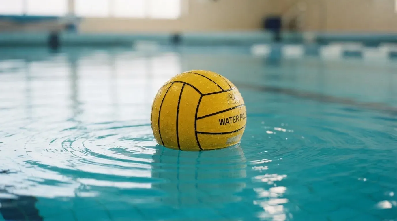 Ein gelber Ball treibt auf ruhigem türkisfarbenem Beckenwasser, feine Wellen im weichen Licht.
